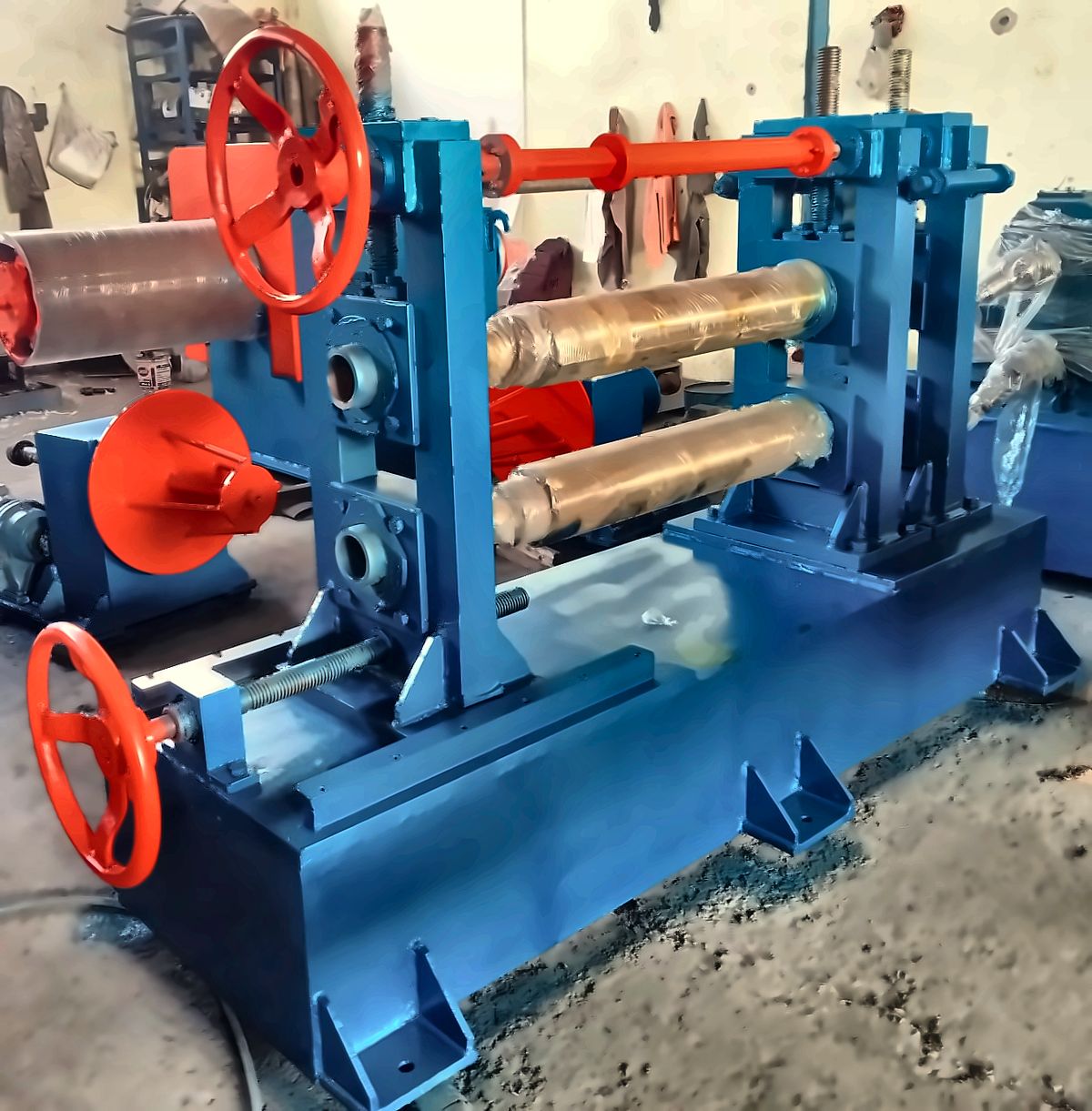 Roll stack with adjustment handwheel on a blue machine frame